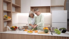 Older Asian couple lovingly prepares fresh vegetables together in a bright contemporary kitchen promoting a wholesome healthy lifestyle - Powered by Shutterstock - Get 15% off with code: PIKWIZARD15