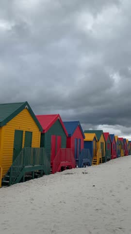 Colorful beach huts at the ocean coastline. Muizenberg beach. A small village near Cape Town. South Africa.Vertical video.