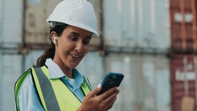Female engineer wearing safety helmet and vest using smartphone for online video call at construction site. Modern architect communicating digitally during work inspection. - Powered by Shutterstock - Get 15% off with code: PIKWIZARD15