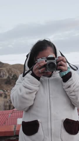 Young girl learning to take pictures with analog camera
