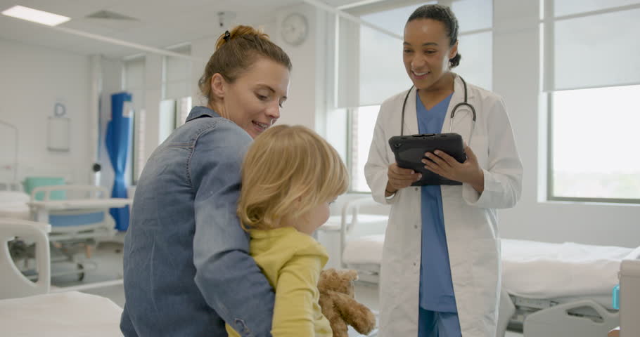 Child doctor visit with nurse and parent sitting on Hospital bed