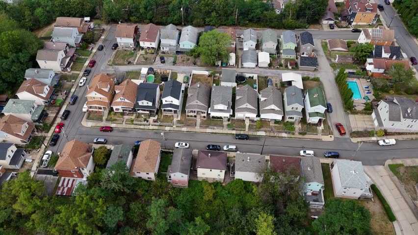 Drone aerial of a typical middle-class Pennsylvania neighborhood, featuring tree-lined streets, family homes, and suburban charm from above. 14801  	