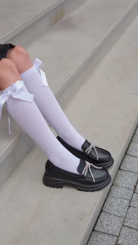 Close-up of black shoes for a girl with elegant bows. Children's fashion concept.