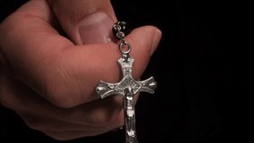 Hand holding rosary beads and crucifix on dark background - Powered by Shutterstock - Get 15% off with code: PIKWIZARD15