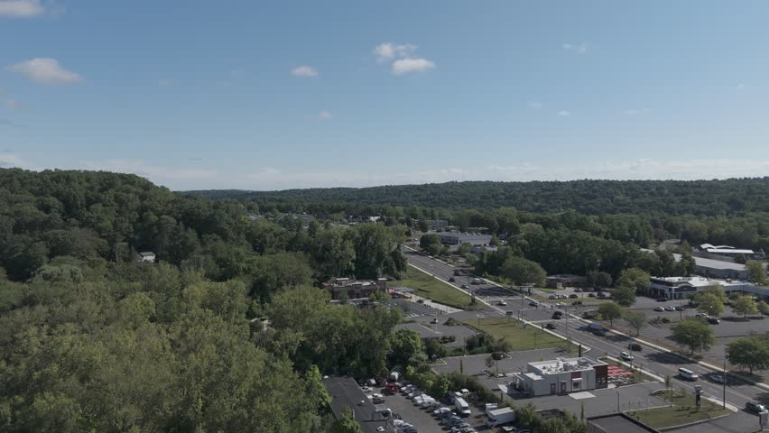Aerial zoom over Brookfield CT showcasing scenic town views, lush greenery, suburban charm, and New England architecture. Ideal for travel, real estate, or local promo use.
