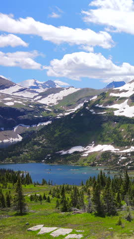 Explore the breathtaking landscapes of Glacier National Park in Montana, featuring impressive mountains, vibrant greenery, and stunning blue skies that will leave you in awe on your outdoor adventure