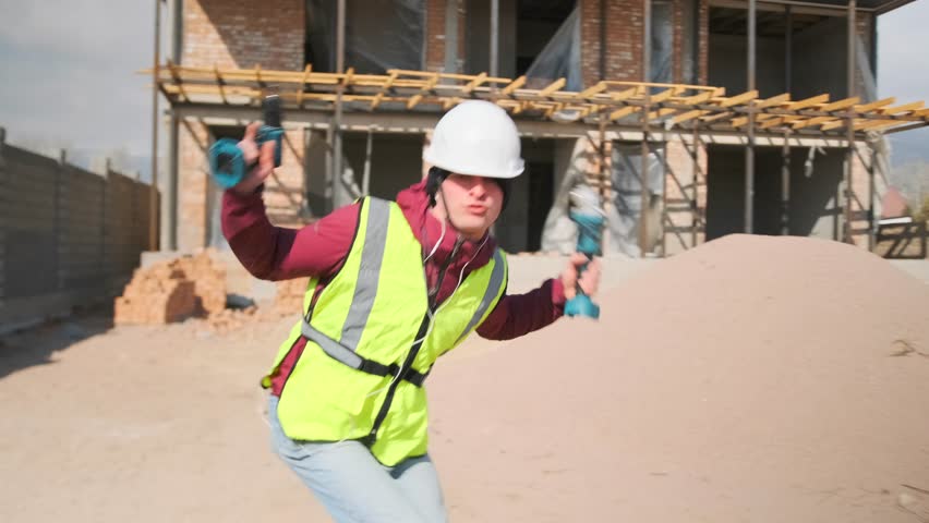 At a construction site, a slacker in a hard hat and vest dances wildly with a drill, swinging his arms to the music. Filled with carefree energy, he turns a quick break into a noisy distraction.