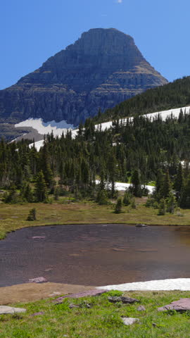Explore Glacier National Parks breathtaking landscapes, featuring majestic mountains, serene ponds, and lush greenery, perfect for nature lovers and adventurers seeking beauty in the wilderness