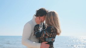 Wrapped in an embrace, eyes closed and foreheads touching, a young couple shares a tender moment. The woman cradles his head as the autumn sea shimmers in the sunlight behind them. - Powered by Shutterstock - Get 15% off with code: PIKWIZARD15