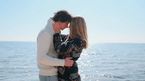 A couple stands embraced on the shore, eyes closed and foreheads touching. Behind them, the sea sparkles in the sunlight, filling the moment with tenderness and romance. - Powered by Shutterstock - Get 15% off with code: PIKWIZARD15