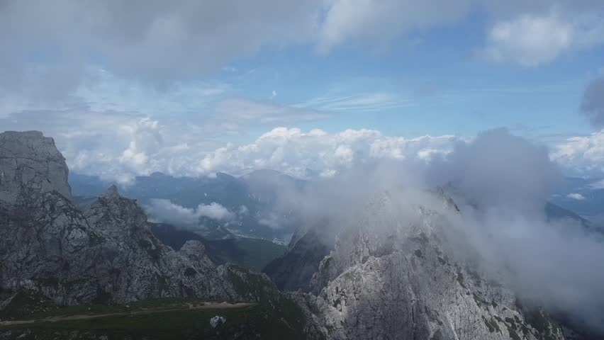 Aerial drone flight over Mangart mountain in the Julian Alps, Slovenia, capturing dramatic peaks, alpine landscape, and stunning natural scenery ideal for travel and adventure projects.