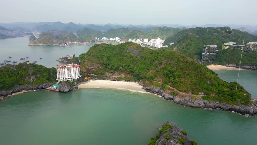 Aerial view of Cat Ba Island in Ha Long Bay, Vietnam. Scenic coastline with tropical hills and sandy beaches surrounded by emerald waters. Popular travel and tourism destination.