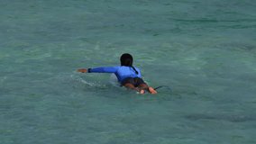 Slow motion video of asian young woman wearing sun protection clothes swims in Indian ocean.Vertical video - Powered by Shutterstock - Get 15% off with code: PIKWIZARD15