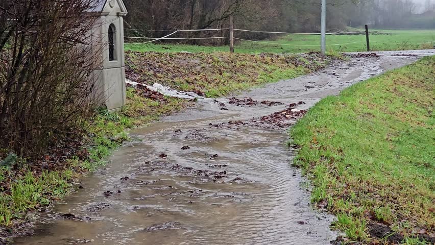 Flooding on a Trail Water Rushing Down a Muddy Path after Heavy Rain