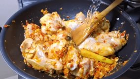 A slow-motion shot captures seasoned chicken, infused with herbs and chili, being stir-fried in a wok. - Powered by Shutterstock - Get 15% off with code: PIKWIZARD15