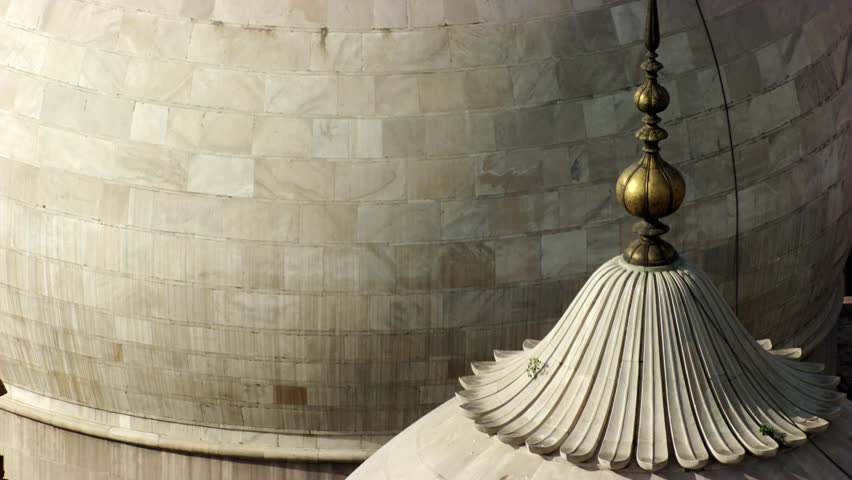 A close-up view of three intricately designed domes and a red sandstone minaret from a historic Badshahi Mosque in Lahore, Pakistan. An aerial view of the majestic Mughal architecture.