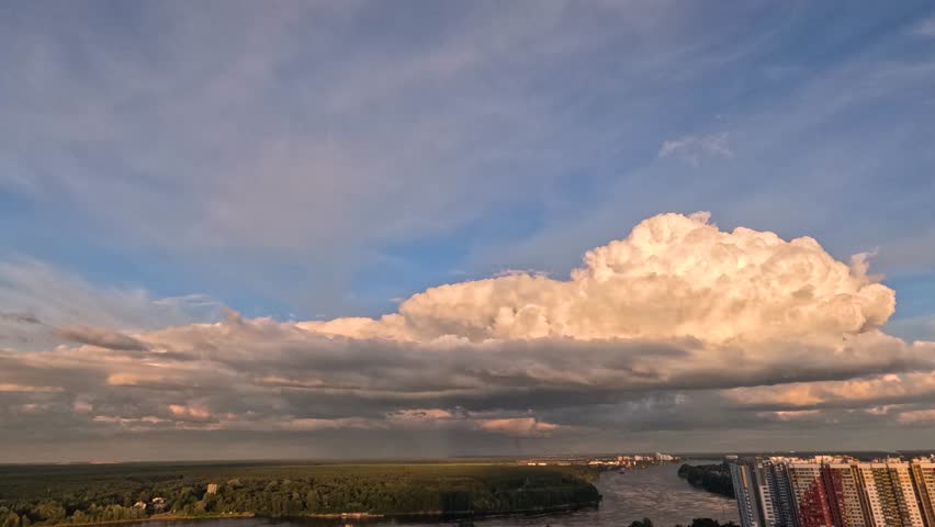 Timelapse displays the changing weather and beautiful cumulus clouds moving across the sky above the Neva River and urban landscape during a summer evening in Saint Petersburg, Russia