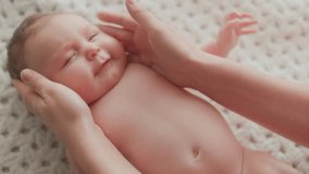 Close-up of a smiling baby holding mother hands while lying on a soft blanket indoors, showing joy, tenderness, bonding, and loving family connection. - Powered by Shutterstock - Get 15% off with code: PIKWIZARD15