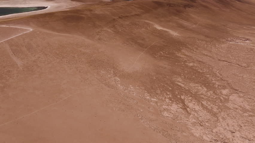 Aerial shot of Mars Valley in the Atacama Desert with golden light hitting the rock formations during a stunning summer sunset in one of the most surreal landscapes in northern Chile