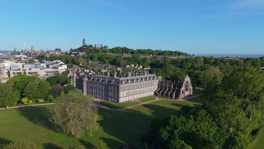 Drone ascends over Holyroodhouse Palace in Edinburgh, gradually revealing the majestic cityscape, historic charm, and Arthur