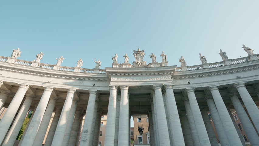 St. Peter's Square colonnade with statues and columns under clear sky in Vatican City, Rome, Italy
