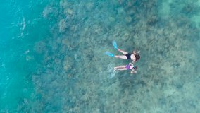 Aerial view of an adult woman and a young girl snorkeling with fins and masks in clear, shallow turquoise ocean water, Boracay, Philippines. - Powered by Shutterstock - Get 15% off with code: PIKWIZARD15