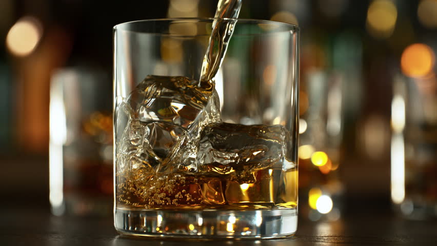 Super Slow Motion Shot of Pouring Whiskey into Glass with Ice Cubes at 1000fps with Camera Movement.