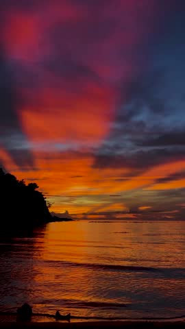 Dramatic orange and red sunset over tropical ocean