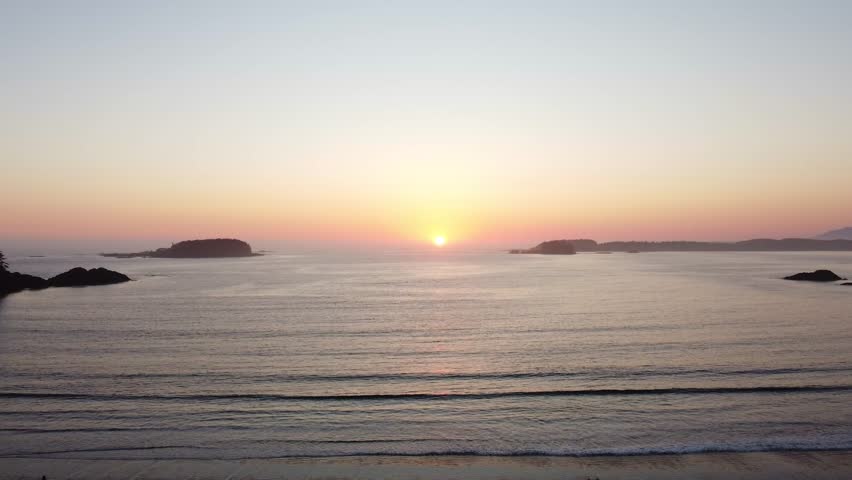 Drone footage over vast ocean, islands, at sunset