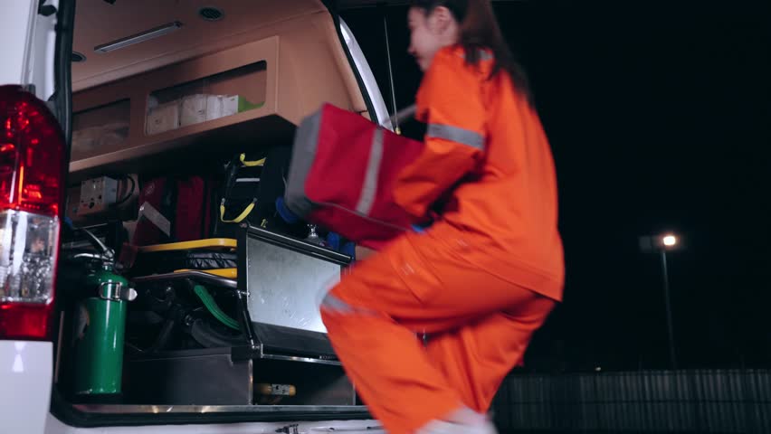 Emergency medical technician (EMT) team or paramedic nurse walking and jumping to ambulance car