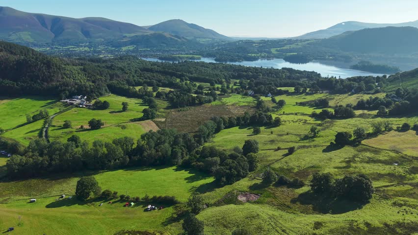 Aerial view of green fields, mountains, and Derwent Water in the Lake District, UK