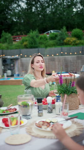 Family enjoying summer barbecue in backyard.