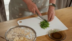 A chef mincing fresh basil on a cutting board. The process of preparing an aromatic green garnish or a base for a homemade pesto sauce with healthy, natural ingredients. - Powered by Shutterstock - Get 15% off with code: PIKWIZARD15