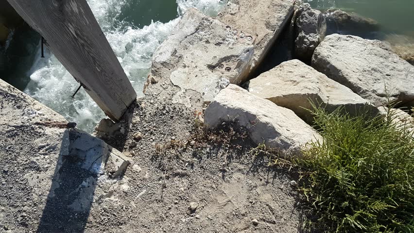 Torrents of water rush through floodgates in the Carboneros marshes, Chiclana de la Frontera, Cádiz, Spain. A dynamic scene of nature, flow, and hydraulic infrastructure.