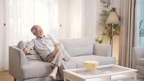 Happy Asian senior man watching movie using remote control change change on smart TV in living room. Elderly man enjoy leisure activity hobby indoor lifestyle at home. Retired people mental healthcare - Powered by Shutterstock - Get 15% off with code: PIKWIZARD15