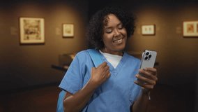Woman smiling while holding smartphone and backpack strap in building; digital connection joy discovery. - Powered by Shutterstock - Get 15% off with code: PIKWIZARD15