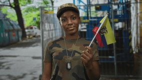 Young woman soldier holding flag beside scaffolding at construction site wearing camouflage cap; pride support solidarity. - Powered by Shutterstock - Get 15% off with code: PIKWIZARD15