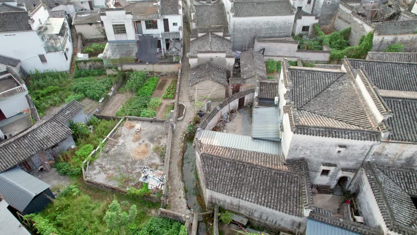 Drone view villages and farmlands among green mountains, high angel view rural buildings in autumn day, 4k real time footage b roll shot, Nanping village, Yixian, Anhui, China.