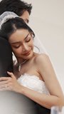 Asian bride hugs her groom close with her eyes closed, feeling safe and calm in a peaceful wedding moment. - Powered by Shutterstock - Get 15% off with code: PIKWIZARD15