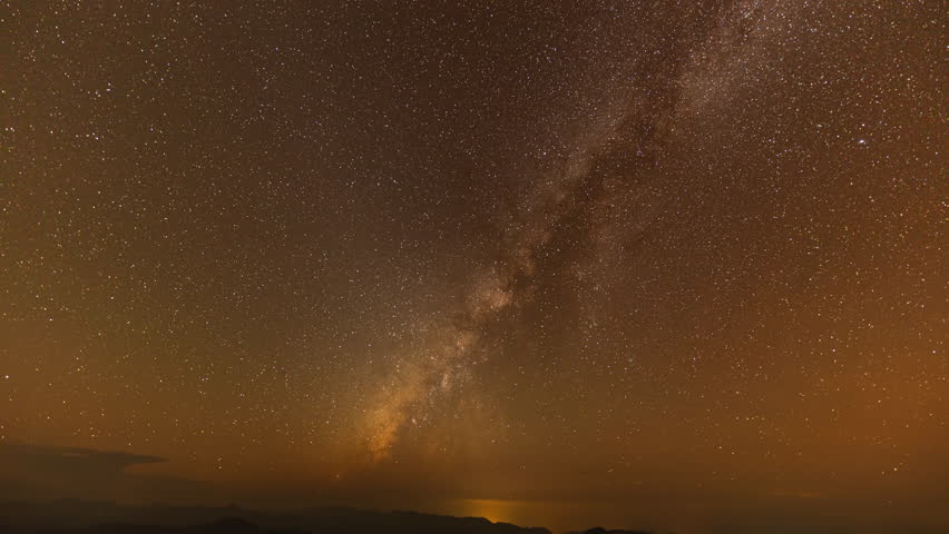 The Milky Way is bright and clear in the dark sky on Doi Chik Chong in Mae Hong Son Thailand. It is a remote place with beautiful nature and fresh air.The Milky Way orbits over a steep mountain range
