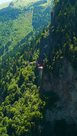 Vertical video. Altindere, Trabzon Province, Turkey. Sumela Monastery. Altindere Valley Park. Coniferous forest on the slopes, Aerial View. Rich colors