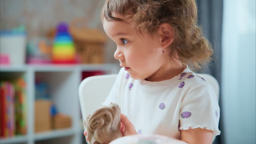 A Playful Moment: A Young Child Engaging with a Clay Figurine in a Colorful and Inviting Playroom Environment, Captured in Two Frames of Joyful Creativity