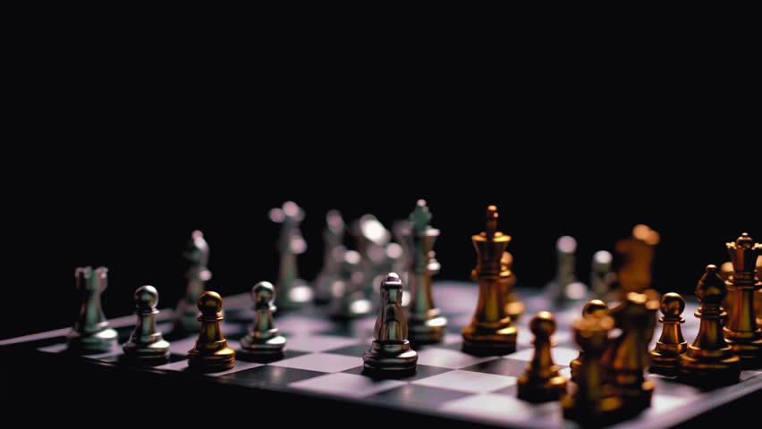 Close up of a man moving silver king chess piece on chessboard. Concept of business strategy, planning, leadership, competition, and victory.