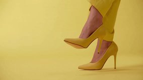 A Woman Showing Her Heels in Monotone Yellow Studio | Stylish Female Footwear Display, Modern Monochrome Fashion Concept in 4K Ultra HD - Powered by Shutterstock - Get 15% off with code: PIKWIZARD15