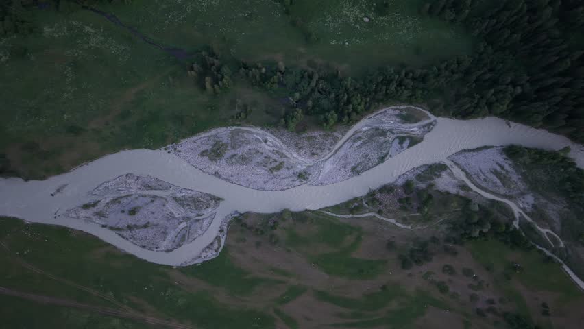 Verdant valley meandering with river waters during twilight hours, revealing serene landscape stretching across untouched wilderness under evening