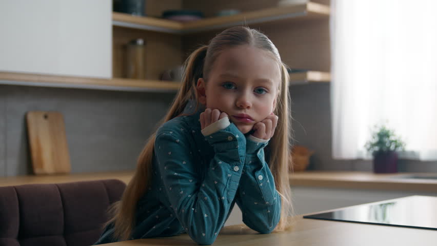 Portrait upset frown little offended Caucasian child girl kid at kitchen say no answer not shaking head looking at camera negative disagree family misunderstanding daughter unhappy displeased at home