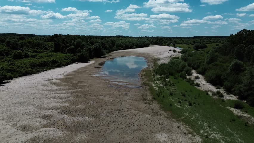 Aerial view of Danube River meandering through forested landscape and sandbanks near Belegis, Serbia. A long coastline with sand along the river. Horizontal 4k footage