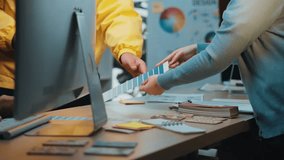 A vibrant workspace captures two professionals engaged in a collaborative design session, evaluating color swatches and mockups, fostering creativity and teamwork. SACTR - Powered by Shutterstock - Get 15% off with code: PIKWIZARD15