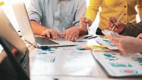 A diverse team collaborates on a project in a modern office, using a laptop and colorful documents to analyze data and discuss strategies for success. SACTR - Powered by Shutterstock - Get 15% off with code: PIKWIZARD15