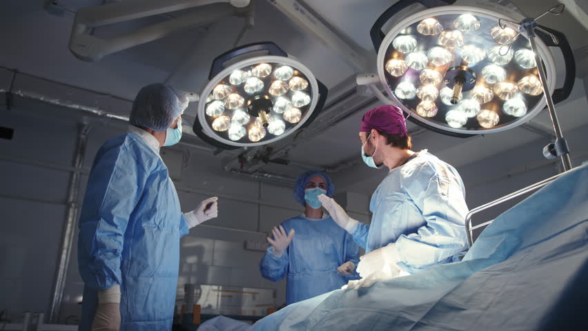 Medical team celebrating a successful surgery, high-fiving in a modern operating room. Medical Team Celebrates Surgery Success